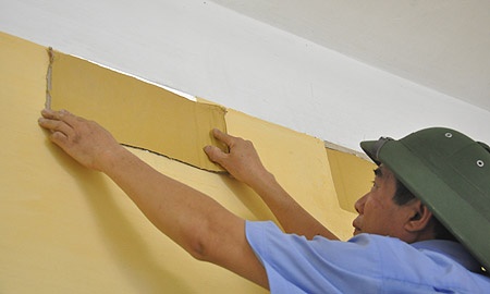 Bảo vệ dùng bìa các-tông che các ô thông khí của phòng thi gần với nhà dân, phòng trường hợp đề bị lộ ra bên ngoài.