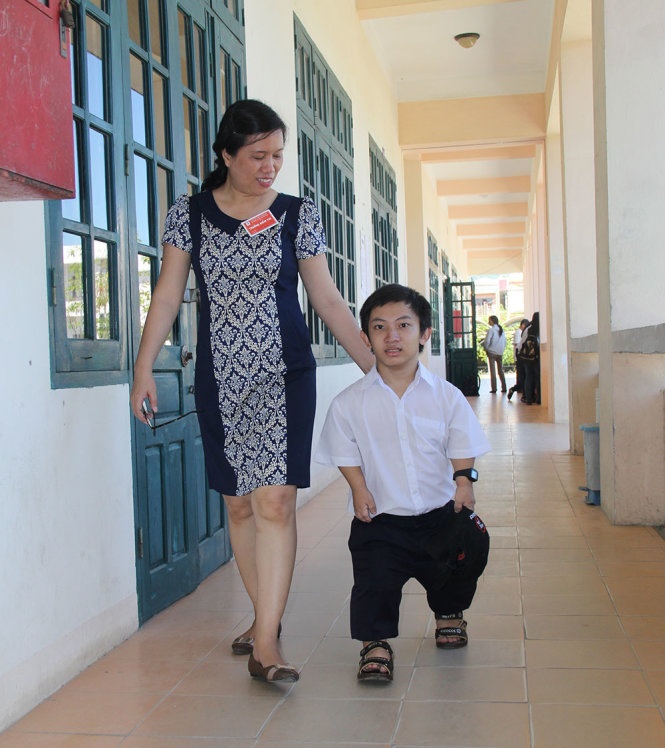 PGS.TS Trương Thị Diễm, trưởng điểm thi khu H Trường ĐH Bách khoa Đà Nẵng đưa thí sinh Nguyễn Đình Phước chọn bàn thi. Ảnh: Trường Trung