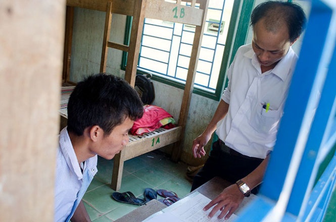 Thầy Nguyễn Thanh Tú, hiệu trưởng trường THPT Bắc Trà My hướng dẫn các em ôn luyện tại khu nội trú của trường - Ảnh: Lê Trung
