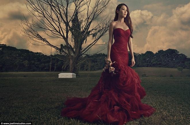 Mặc dù chủ đề của bộ ảnh là khá “dị”, đôi vợ chồng sắp cưới này trông vẫn rất đẹp. Cô dâu trong bộ váy đỏ dài còn chú rể mặc bộ tuxedo sang trọng. Họ như xích lại gần nhau trong quan tài tại công viên nguyên thủy ở Singapore.