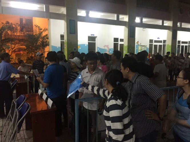 Chờ đợi trong sân trường lúc 5g sáng - Ảnh: Quang Phú