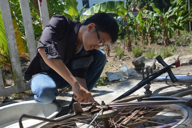 Hậu “ròm” vá vội chiếc xe đạp cà tàng để đạp đến chỗ dạy kèm cách nhà hơn 10km - Ảnh: Thanh Ba