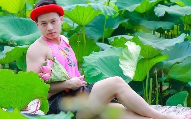 Chang trai mac ao yem tao dang ben ho sen hinh anh