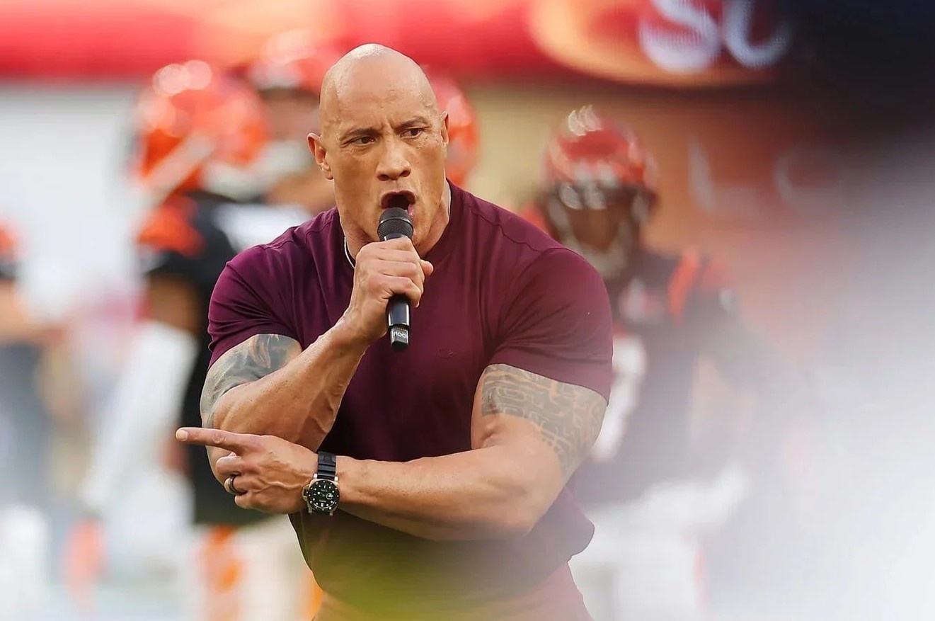 Dang sau ve ngoai co bap cua The Rock tai Super Bowl hinh anh
