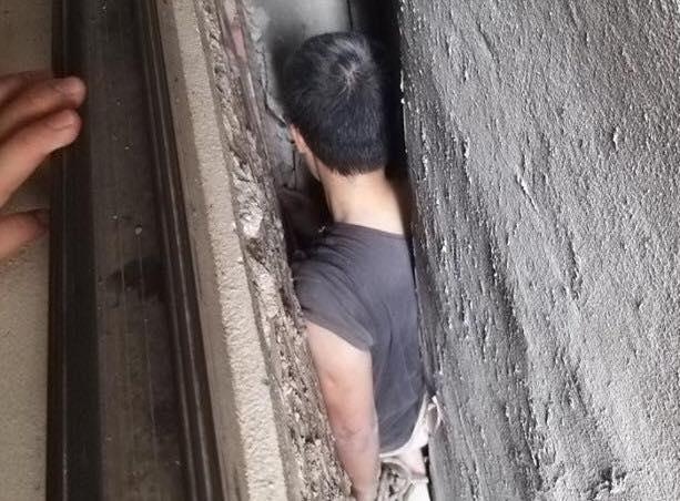 Nguoi dan ong mac ket o khe ho giua 3 ngoi nha hinh anh