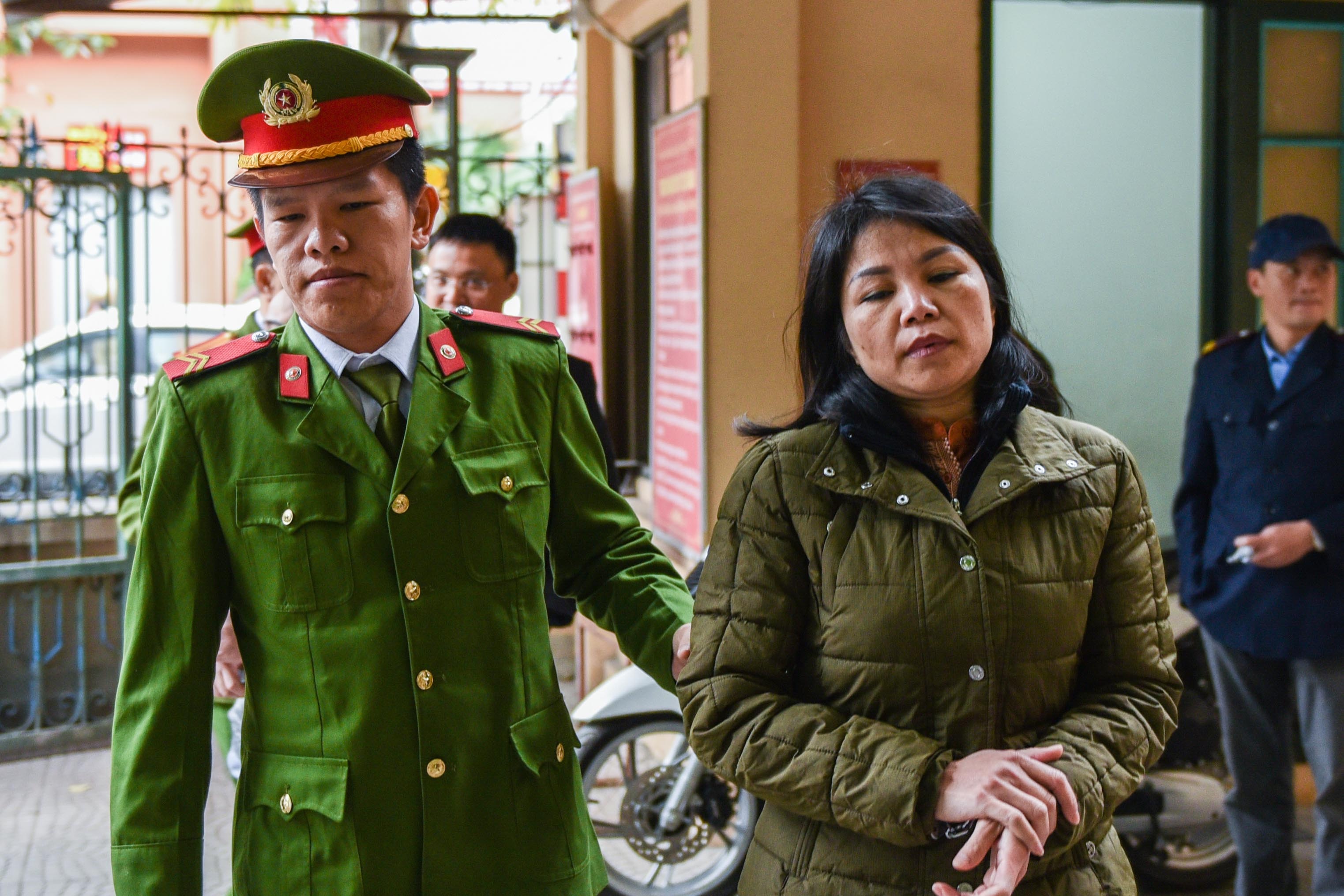 Hoan xu nu canh sat nhan tien day doanh nhan vao tu hinh anh