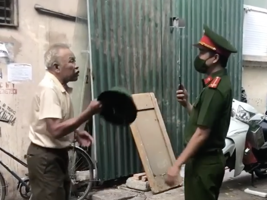 Bi nhac deo khau trang, nguoi dan ong dung mu coi danh cong an hinh anh