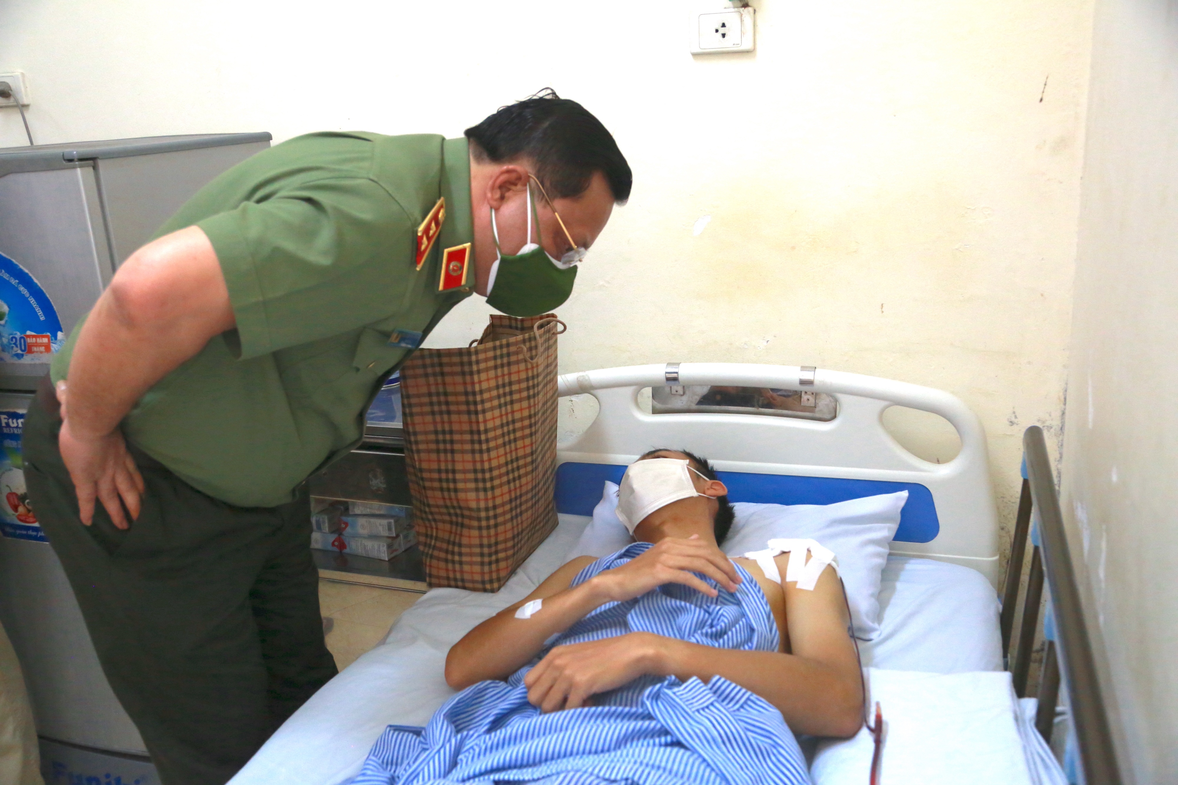 Giam doc Cong an Ha Noi tham thuong uy cong an bi shipper tong hinh anh