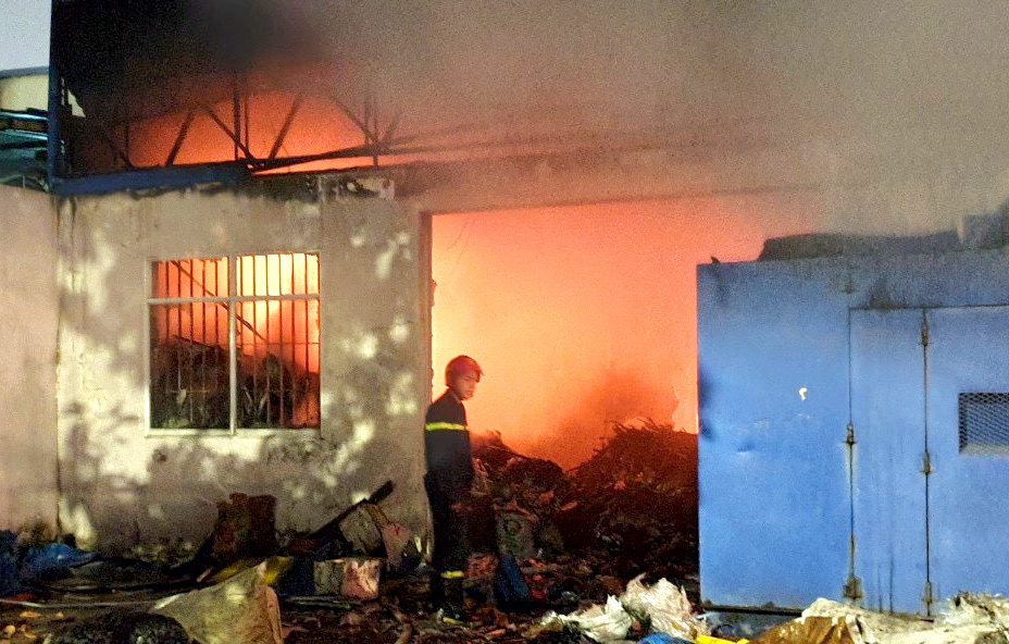 Nguoi dan di doi do dac ra xa kho phe lieu dang boc chay hinh anh