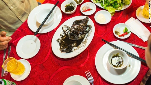 Bourdain và Linh thưởng thức món lươn nướng của nhà hàng.  