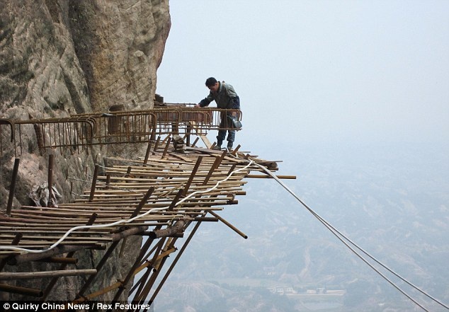 7. Đường trên trời bằng gỗ, núi Shifou, Trung Quốc: Không để tỉnh bạn qua mặt, cách đó 130km, tỉnh Hồ Nam đã xây dựng một đường trên trời bằng gỗ vô cùng độc đáo ở núi Shifou. Con đường rộng chưa đầy 1m được làm từ ván gỗ nằm ở độ cao 300m so với mặt đất, kéo dài gần 3km. Đây là đường ngắm cảnh dài nhất Trung Quốc. Ảnh: Wanderlust.co.uk