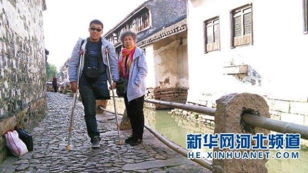 Chang trai cut chan dua me gia di du lich khap Trung Quoc hinh anh