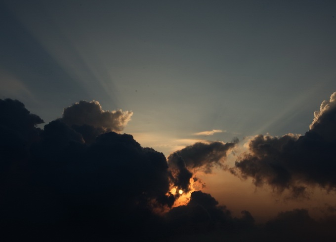 Mặt trời hiện ra tia nắng đầu tiên trong ít giây sau đó ẩn mình trong đám mây - Ảnh: HOÀNG THẠCH VÂN