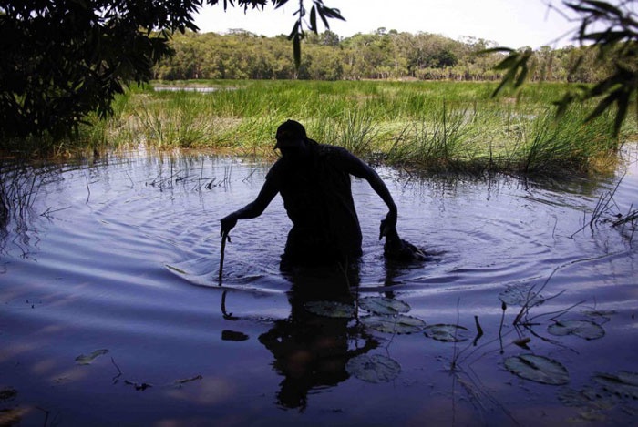Người thợ săn có tên Robert Gaykamangu này vừa bắn được một con ngỗng khi băng qua con sông cụt trên đường đi.