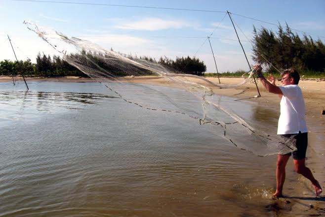 Khách nước ngoài tung lưới đánh cá bên bờ sông Hoài 