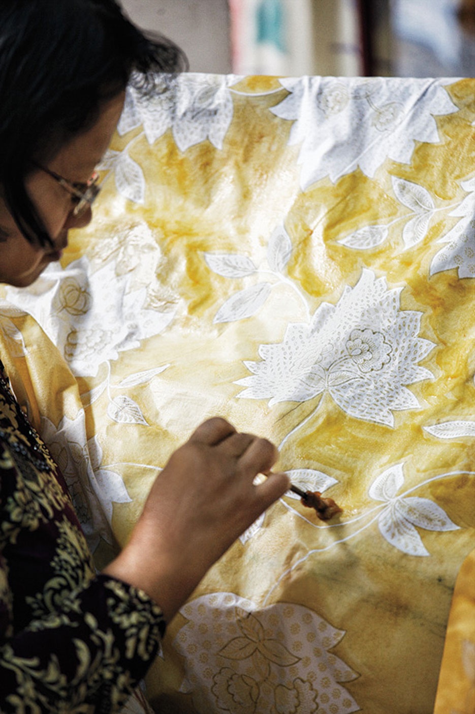 Một nghệ sĩ đang tô màu cho vải lụa bằng tay ở Ardiyanto, nơi sản xuất lụa batik đẹp nhất Yogyakarta suốt 40 năm liền. Các xưởng lụa batik rực rỡ sắc màu với những dải lụa và vải treo khắp nơi, chờ vẽ hoặc nhuộm màu.