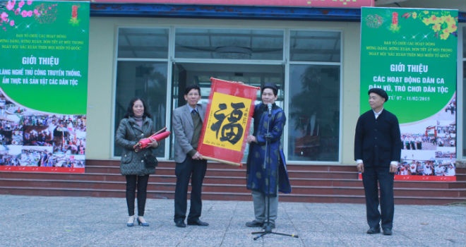 Nghệ nhân thư pháp tặng chữ đầu xuân cho Làng Văn hóa - Du lịch các dân tộc Việt Nam. Ảnh: Cao Thùy Liên