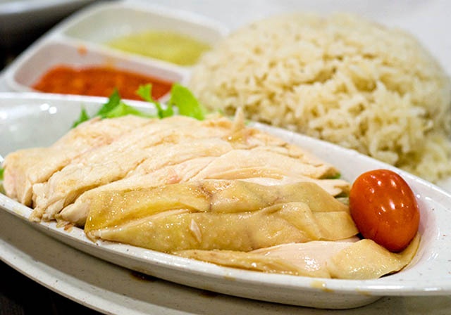 1.	Cơm gà Hải Nam: Nếu bạn hỏi đâu là món ăn phổ biến nhất Singapore, rất có thể, mọi người sẽ trả lời cho bạn hai đáp án. Đó là cua xốt ớt và cơm gà Hải Nam.  Với món cơm gà, bạn có thể tìm thấy ở hầu hết mọi nơi tại Singapore, từ các nhà hàng sang trọng đến các quầy hàng nhỏ trên phố. Món ăn hấp dẫn với miếng gà hấp thơm ngọt dọn kèm phần cơm nóng xốt, dẻo thơm, vài lát dưa leo và nước xốt gừng.