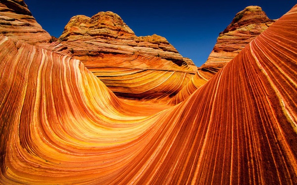 1. Sa thạch The Wave, Arizona, Mỹ: Sa thạch The Wave được hình thành ở phía bắc Coyote Buttes, sa mạc Arizona. Nó được tạo nên từ các cồn cát xếp chồng lên nhau cùng sự lắng đọng của muối canxi, tạo nên những đường cong, uốn lượn độc đáo và quyến rũ.