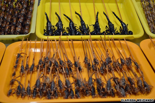 1. Bọ cạp rán: Theo những người bán hàng, việc rán bọ cạp sẽ vô hiệu hóa chất độc của chúng. Điều đáng ngạc nhiên là phần đuôi lại giàu dinh dưỡng nhất.  Trong quyển Bản thảo cương mục, Lý Thời Trân viết bọ cạp là một nguyên liệu quý giá, có khả năng giảm đau và tăng cường tuần hoàn máu. Món bọ cạp rán có đủ kích cỡ, từ nhỏ tới to. Những con lớn có vỏ đen còn con nhỏ hơn thường có vỏ trong hơn. Chúng có vị như bỏng ngô và bơ, thường được chấm với bột ớt. Giá một xiên khoảng 15 nhân dân tệ (hơn 50.000 đồng).