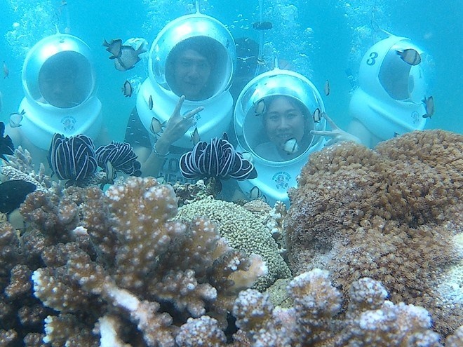 Du khách chụp ảnh lưu niệm trong lòng biển.