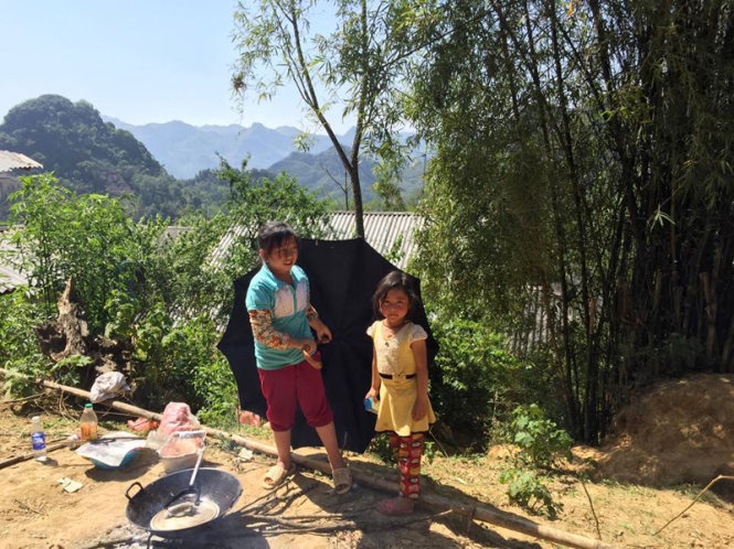 Hai cô bé bán bánh tam giác mạch trên đường.