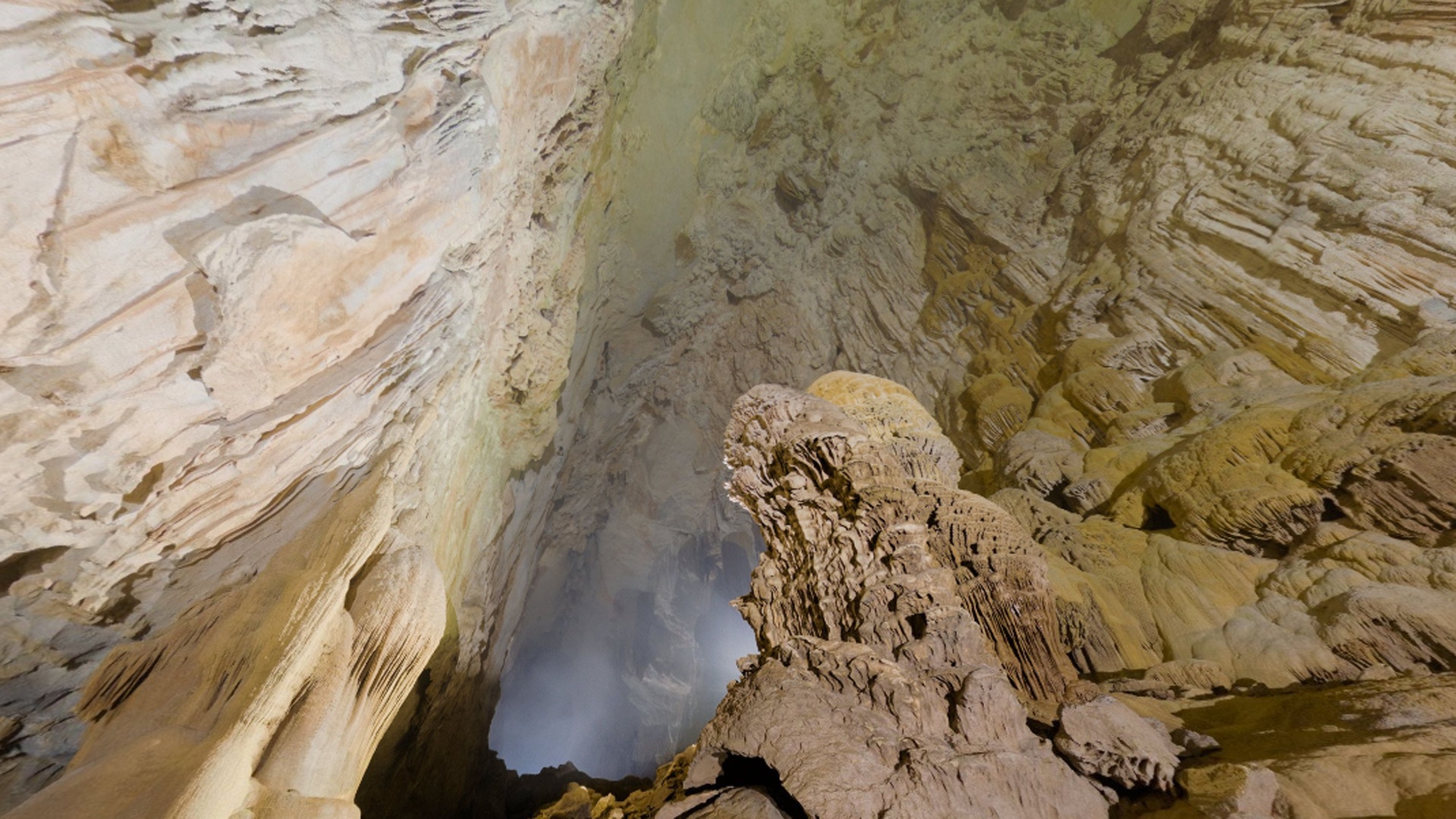 Khung cảnh trong hang thật lộng lẫy. Nhìn về phía Bắc, bạn sẽ thấy nhiều cột thạch nhũ khổng lồ được hình thành sau hàng triệu năm. Nhìn về phía Nam, bạn có thể thấy lối vào thấp thoáng xa xa. Buồng hang nơi ta đang đứng có chiều cao hơn 50 m, và đây mới chỉ là khởi đầu của hành trình tuyệt diệu này.