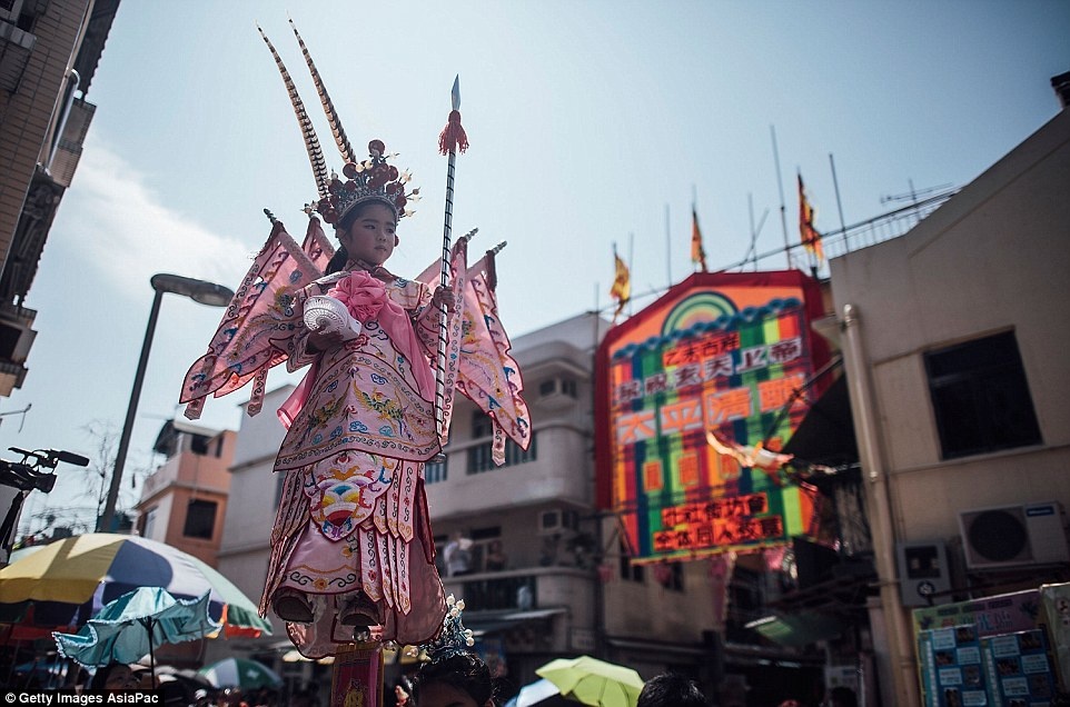 Đám đông chen chân trên các con phố để xem lễ diệu hành Piu Sik, trong đó các em bé được mặc trang phục cầu kỳ như đang bay.