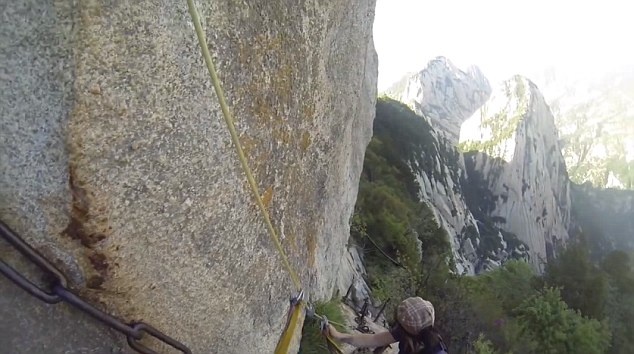 Cặp đôi người Australia móc đai bảo vệ vào một sợi dây xích được gắn dọc vách đá. 