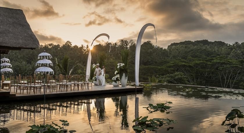 Khu nghỉ dưỡng Four Seasons, Sayan: Để vào resort này, du khách sẽ đi qua một cầu gỗ dài bắc qua một hồ sen, nhìn ra khung cảnh xanh tươi của những rặng tre, đồng lúa và sông. Ảnh: Booking.