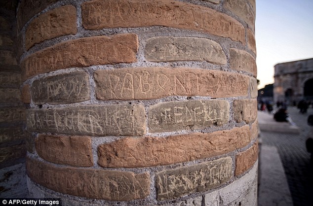 Du khách khắc tên lên tường đấu trường dù hành động này đã bị cấm. Ảnh; Daily Mail.