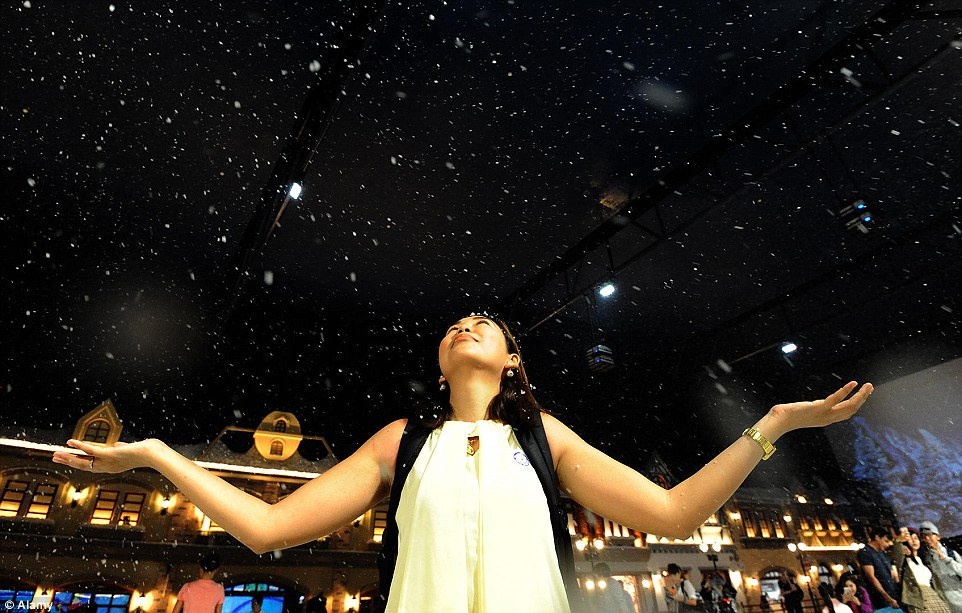 Một phụ nữ thích thú đón những bông tuyết nhân tạo rơi xuống.