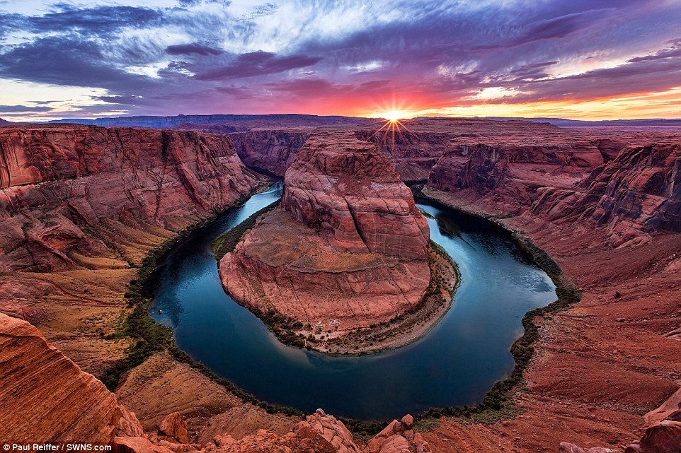 Hoàng hôn ở Horseshoe Bend, Arizona, Mỹ: Những mảng mây lững lờ trên mặt trời, ánh sáng rực rỡ xuống hẻm núi tạo ra khung cảnh như ở một hành tinh khác. 