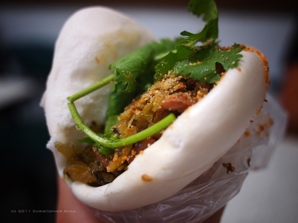 Bánh bao kẹp thịt nướng, Đài Loan, Trung Quốc: Phần thịt lợn nướng béo ngậy và đẫm nước sốt, kết hợp với dưa góp, rau thơm và phần vỏ bánh bao, tạo ra món ăn độc đáo này.