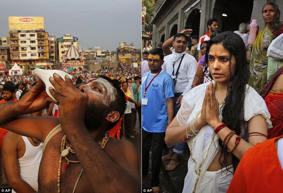 Một giáo sĩ thổi vỏ ốc và một phụ nữ Ấn Độ cầu nguyện sau khi tắm sông.