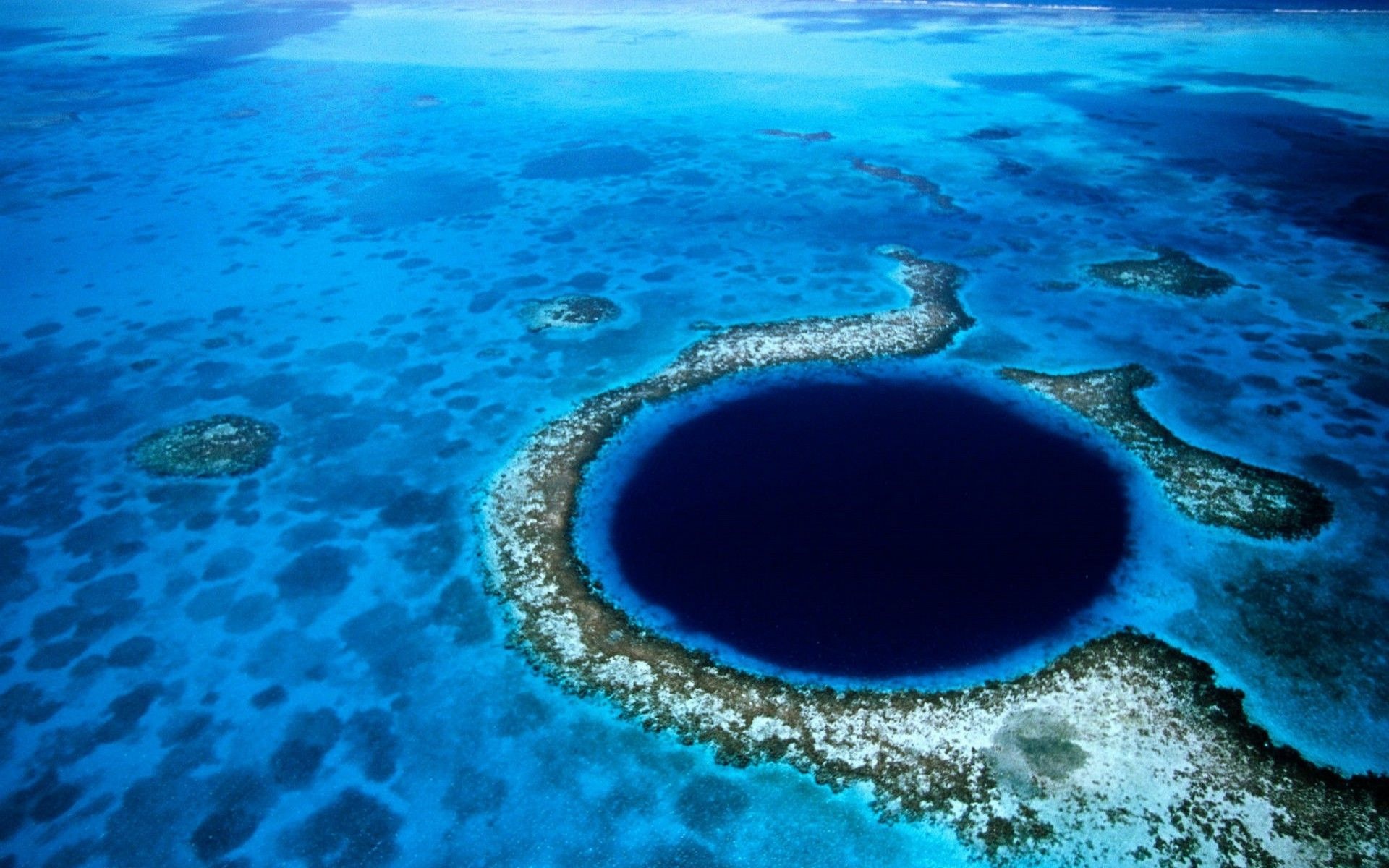 Hố xanh vĩ đại: Great Blue Hole (Hố xanh vĩ đại) là điểm tham quan hút khách của Belize, nhưng không mấy ai biết quá trình hình thành của nơi kỳ ảo này. Khi mực nước biển thấp hơn nhiều so với hiện tại, đây là một hang nội địa. Khi mực nước dâng lên, hang ngập nước và hình thành hố lớn sâu hơn 120 m, với đường kính lên tới 300 m. Các du khách mê lặn thường tới đây để bơi giữa làn nước trong vắt, ngắm nhìn hệ động vật phong phú giữa những rạn san hô tuyệt đẹp.