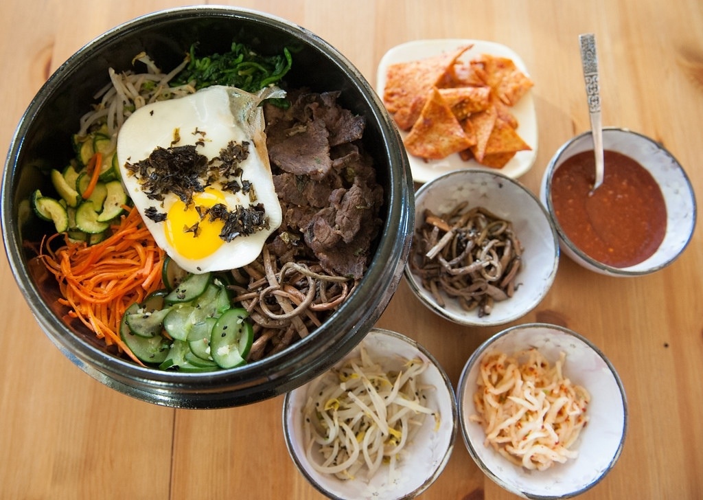 Bibimbap: Cơm trộn kiểu Hàn gồm nhiều nguyên liệu như cơm, rau, thịt bò, trứng, dầu mè và chút tương ớt. Món này có giá khá rẻ và giúp du khách dễ dàng no bụng. Ảnh: Dinnerwithweijia.
