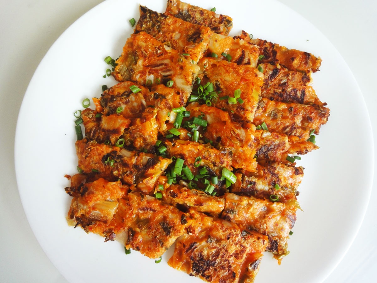 Bánh kếp kim chi: Trộn đều kim chi cải thảo cắt nhỏ, nước kim chi, hành, đường, muối và bột đa năng. Sau đó, cho hỗn hợp bột lên chảo nóng, dàn mỏng và rán cho tới khi bột chín giòn. Loại bánh này có vị ngon khá lạ nhưng hấp dẫn. Ảnh: Maangchi.