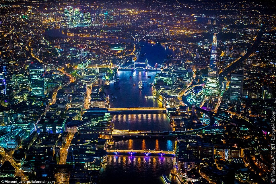 Giữa ánh sáng đủ màu, các cây cầu hiện lên trên mặt nước phẳng lặng của sông Thames.