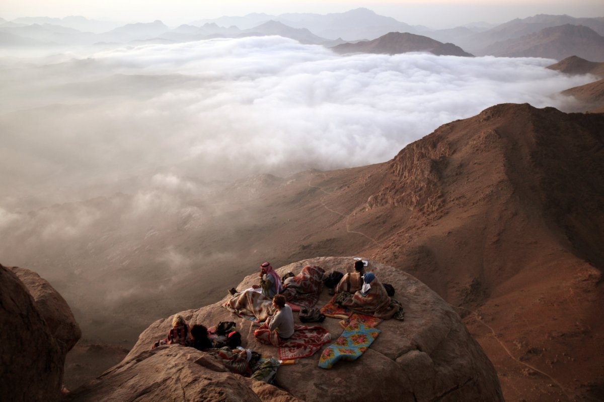 Du khách ngắm mặt trời mọc từ đỉnh Moses ở bán đảo Sinai, Ai Cập. Ảnh: Goran Tomasevic/Reuters.