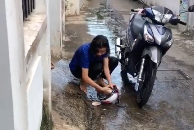 Di chong dich ve, co gai o TP.HCM duoc me phun nuoc tam truoc cong nha hinh anh