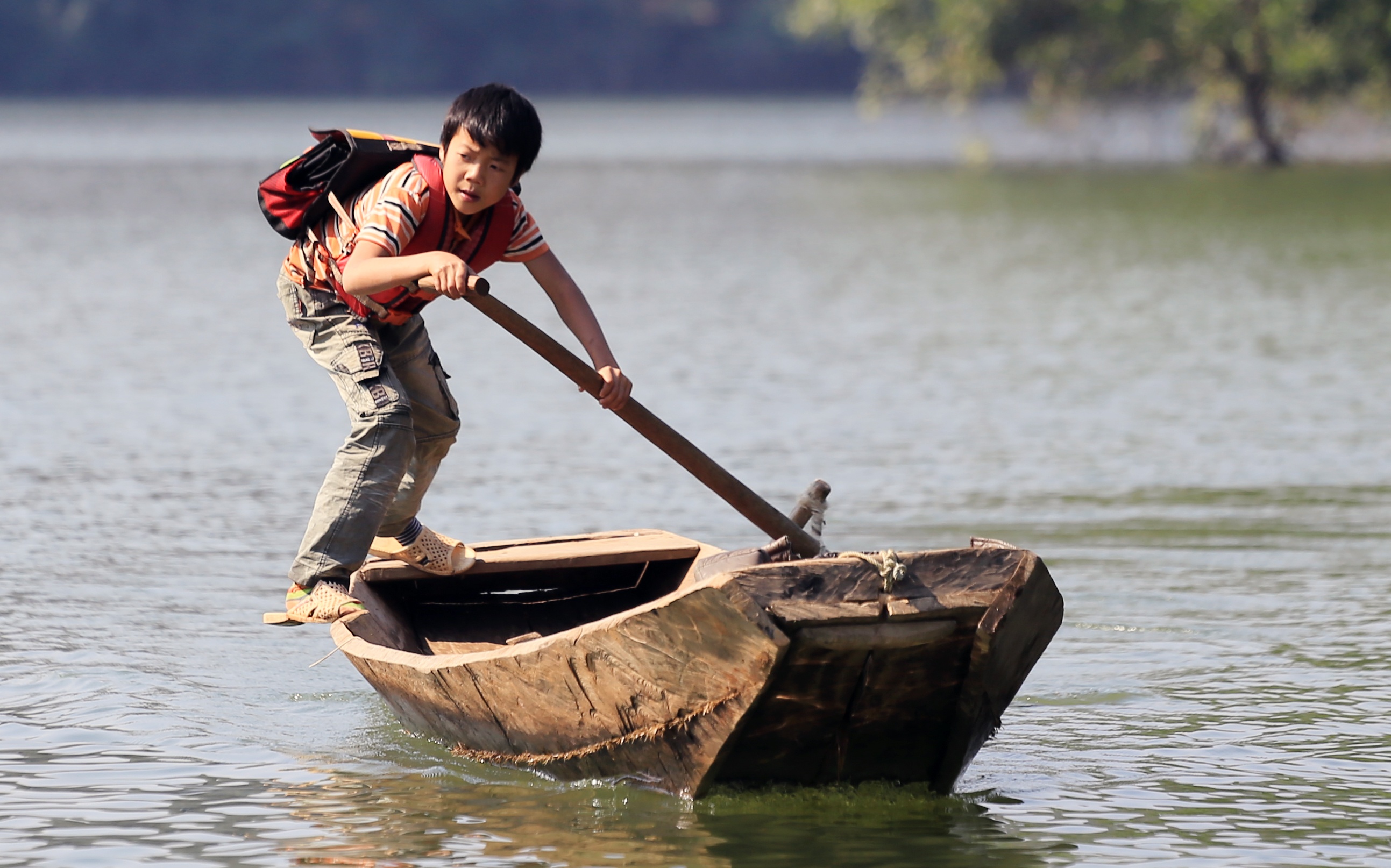 Canh hoc sinh cheo thuyen qua ho nuoc sau den truong hinh anh
