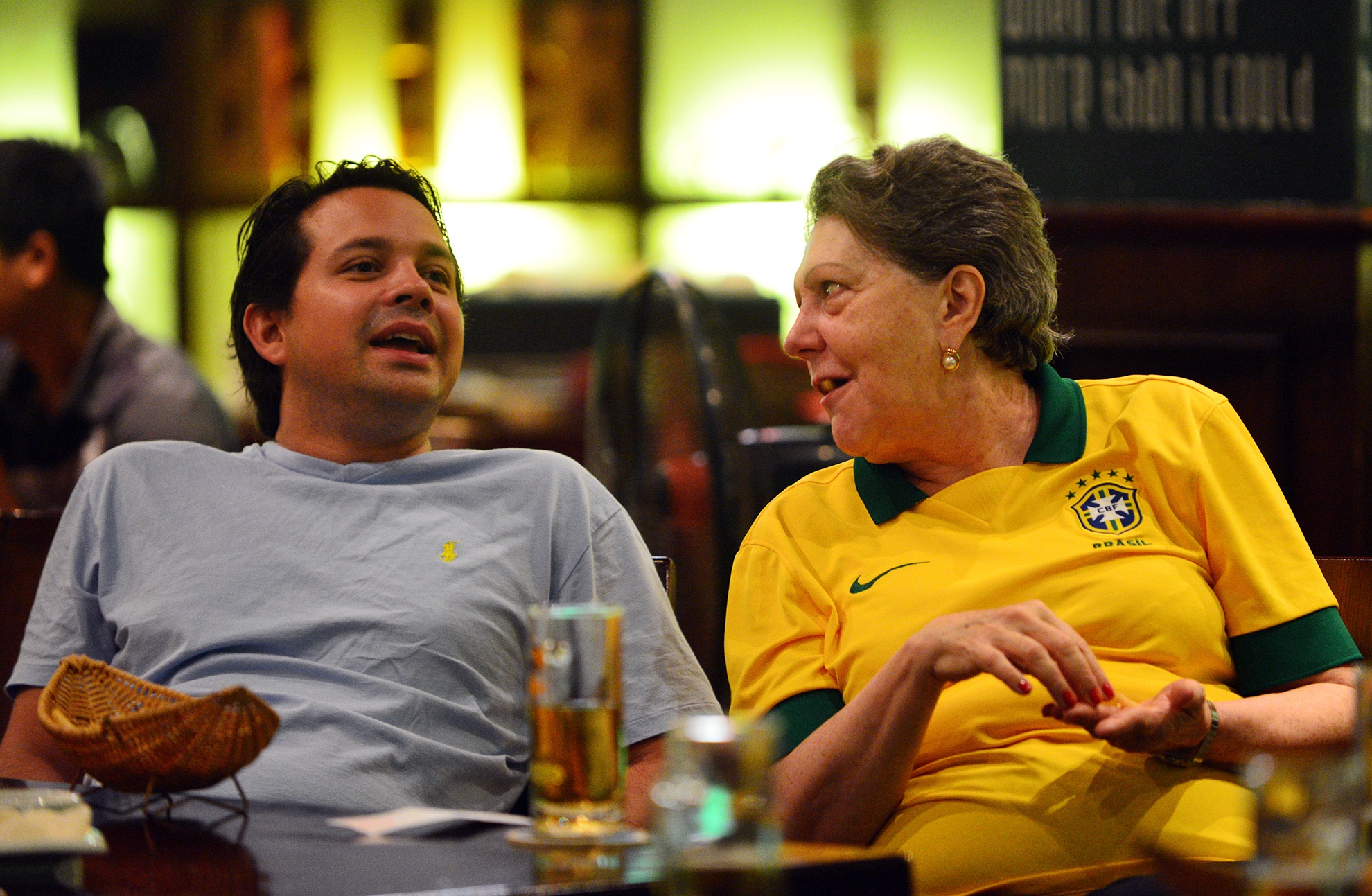 Tuy nhiên, do bị dẫn bàn quá sớm và nhiều trong hiệp 1 khiến không ít các cổ động viên xa quê chán nản. Trong ảnh, bà Vitoria Alice Cleaver Đại sứ Brasil tại Hà Nội trò chuyện cùng bạn bè trong khi trận đấu vẫn diễn ra.