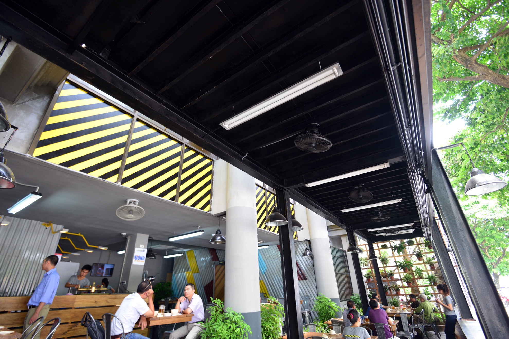 Container được giữ nguyên trạng không sơn sửa. Ngoài ra, các tấm kim loại vỏ ngoài của container hoặc nhôm lợp cũng được chủ quán tận dụng ốp tường. “ Chúng tôi phải tìm tấm kim loại càng cũ càng tốt để tạo nên hiệu ứng cho bức tường”, anh Nam cho hay. Những chi tiết chữ, số in trên container tạo ra vẻ tự nhiên cho nhà hàng.