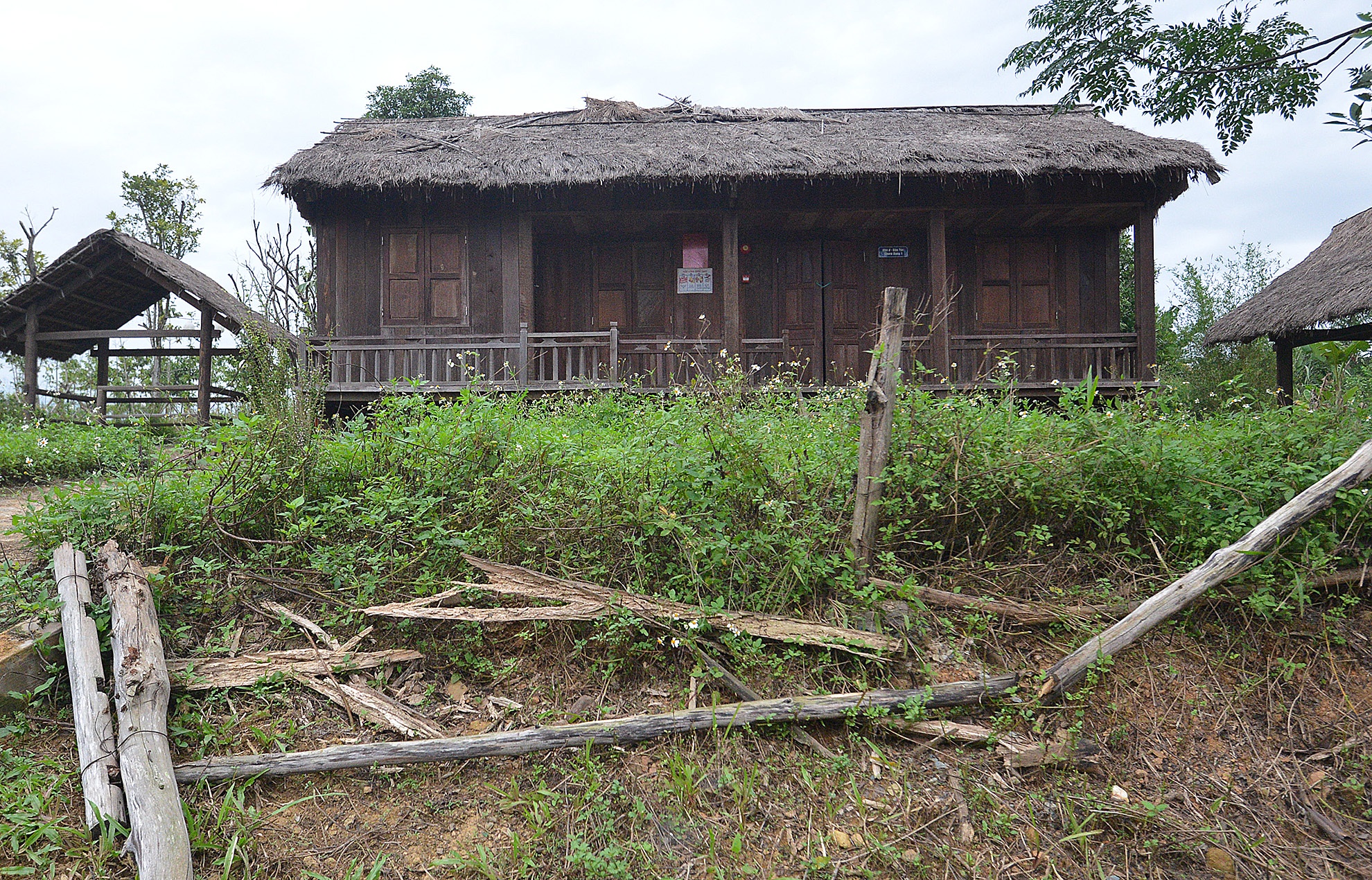 Cảnh tượng hàng rào đổ nát, hoang tàn nhìn từ bên ngoài tại khu nhà người Chu Ru. Không ai nghĩ đây là biểu tượng Văn hoá của một Dân tộc trong khuôn viên làng Văn hoá các Dân tộc.