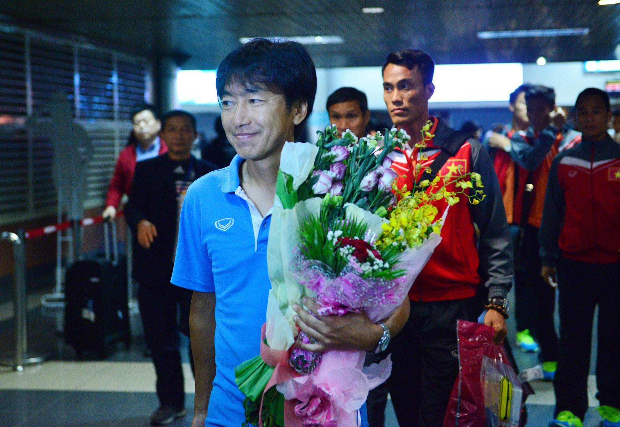 Đúng 18h30, các cầu thủ xuống sân bay, HLV Miura dẫn đầu đoàn chào người hâm mộ.