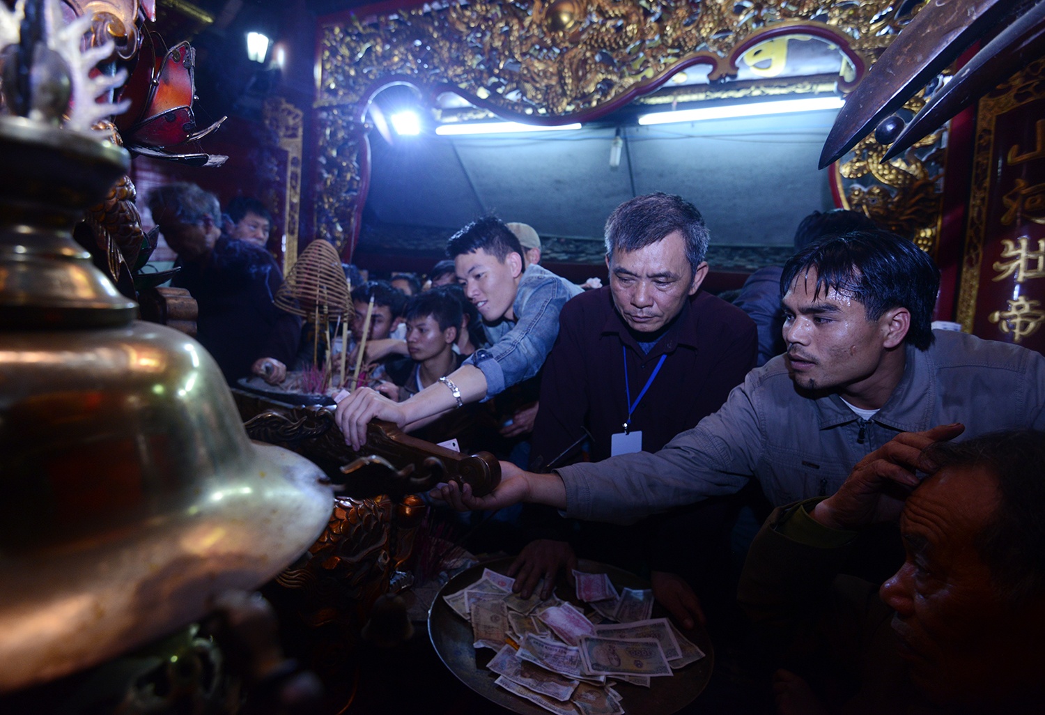 Những người túc trực tại đền liên tục nhắc nhở du khách thập phương không được nhét và xoa tiền lên tượng phật và thanh kiếm nhưng không có tác dụng.