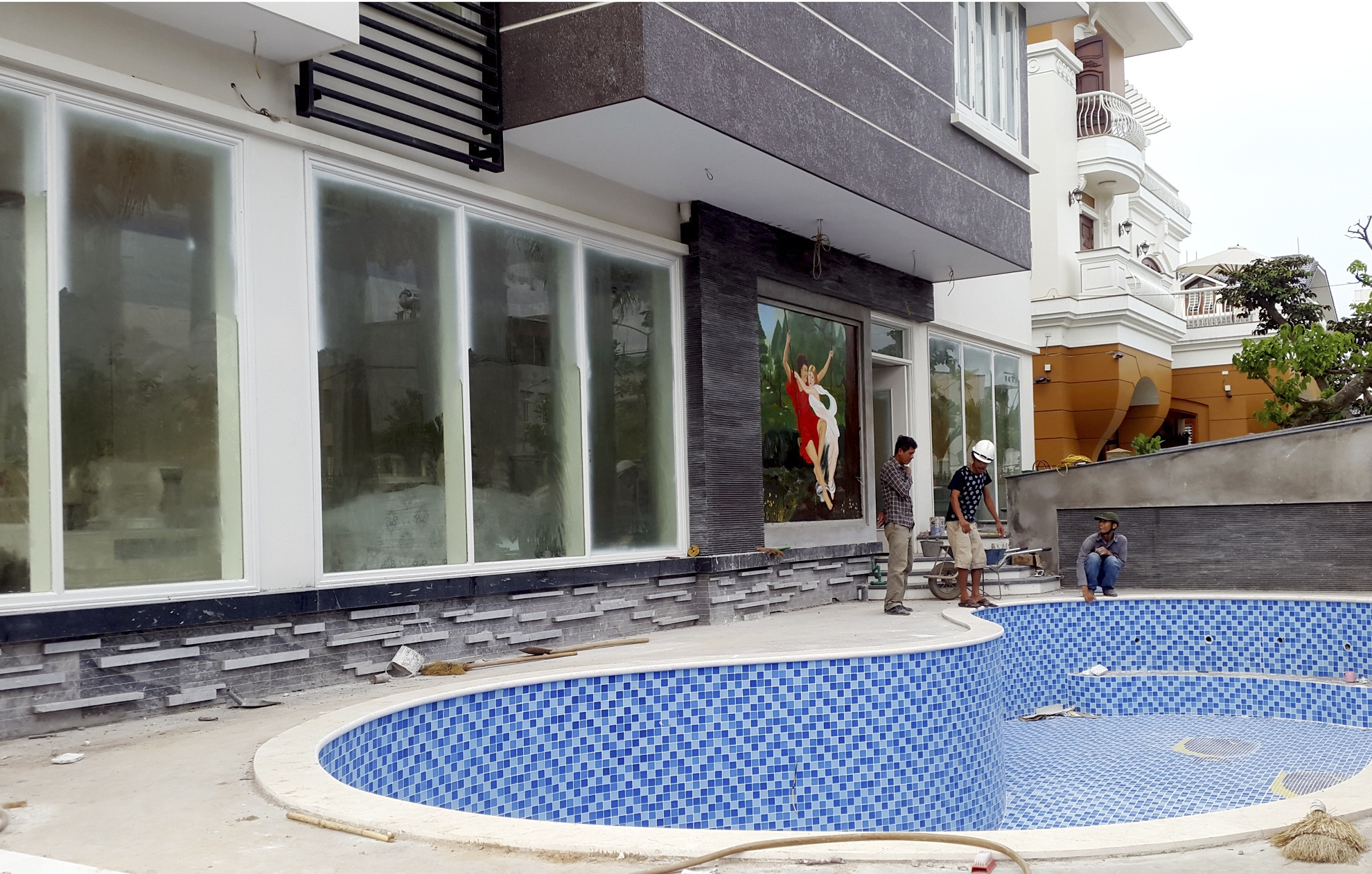 Phía cổng sau được thiết kế theo kiểu biệt thự hiện đại gồm bể bơi, các phòng khách, ngủ được lắp cửa kính hoàn toàn. 