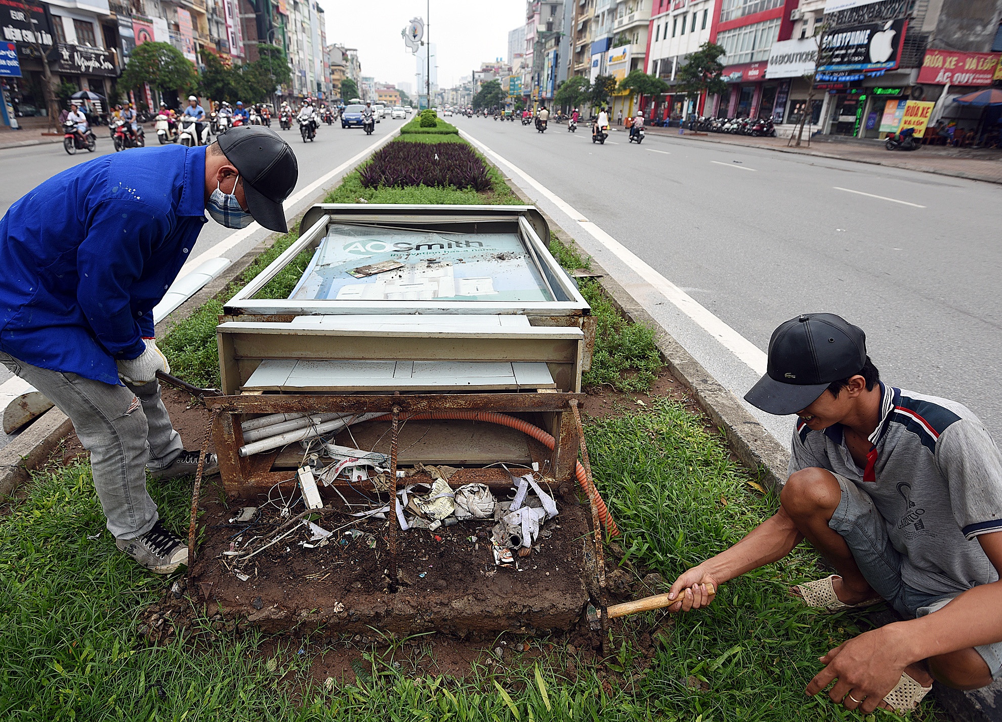 Công nhân khắc phục biển quảng cáo đổ trên đường Đại Cồ Việt.