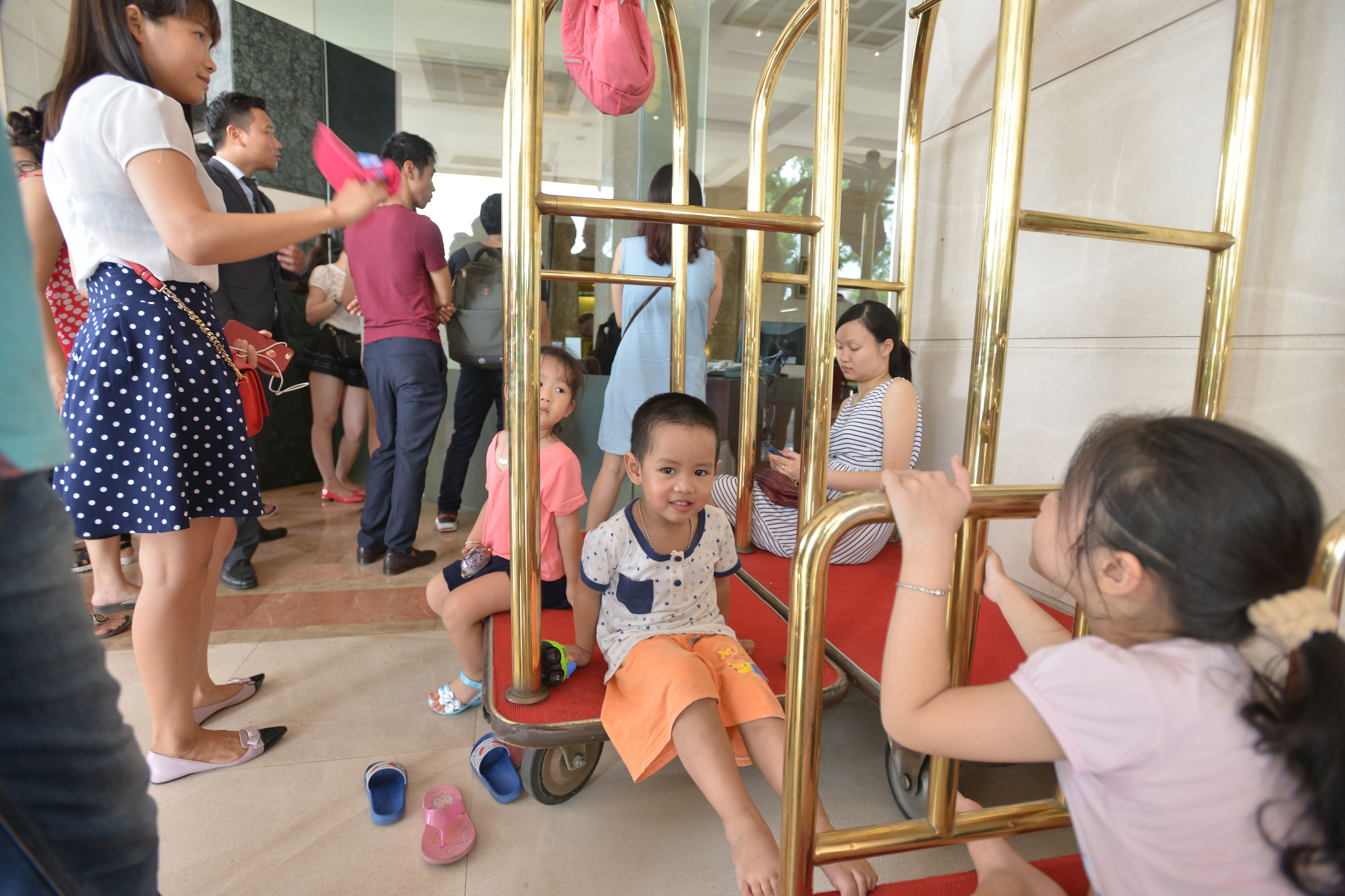 Trẻ nhỏ cũng đi mua sắm cùng bố mẹ. Chị Nguyễn Phương Mai cho con đi mua hàng từ 9h sáng, nhưng chờ đến 11h vẫn không được vào. Chị cho biết, do các cháu nhỏ, không thể chen chúc vào mua hàng được, nên cả 3 mẹ con đành phải ngồi chờ ở sảnh khách sạn. 